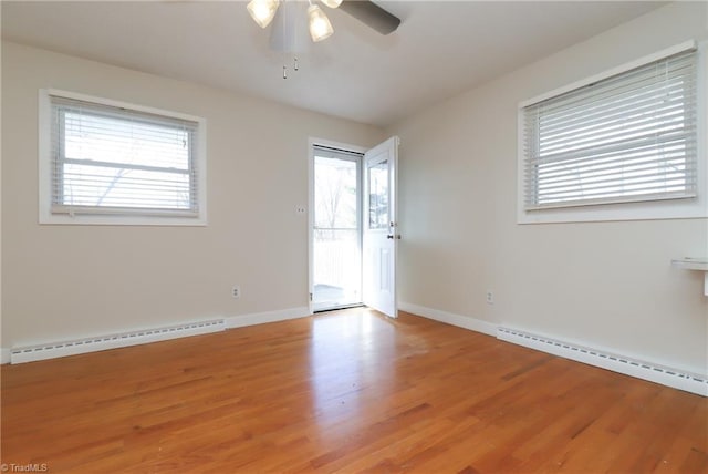 empty room with light wood finished floors, a baseboard radiator, baseboards, and ceiling fan