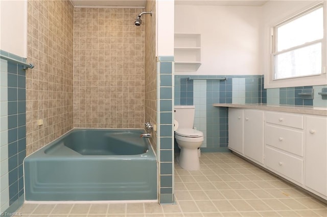 full bath featuring toilet, a wainscoted wall, shower / bath combination, vanity, and tile walls