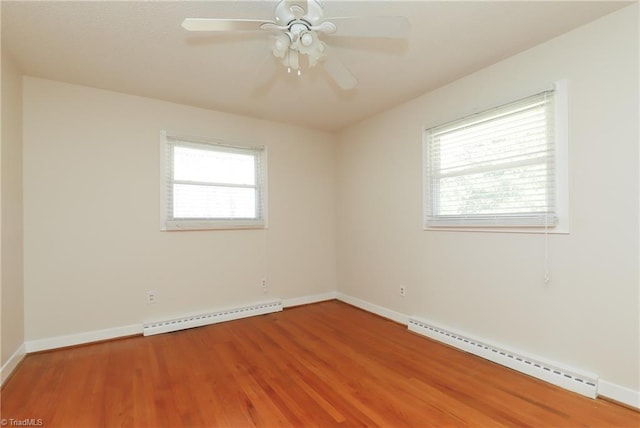 spare room featuring baseboard heating, a baseboard radiator, wood finished floors, and baseboards