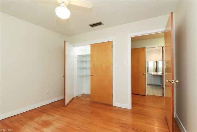 unfurnished bedroom featuring baseboards, visible vents, and light wood-style floors