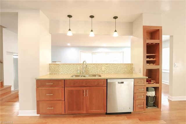 kitchen featuring light stone counters, a sink, dishwasher, light wood finished floors, and brown cabinetry