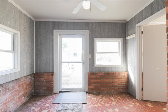 doorway with brick wall, ornamental molding, and a wealth of natural light