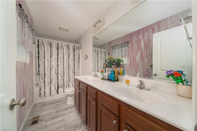 full bathroom featuring hardwood / wood-style flooring, vanity, toilet, and shower / bathtub combination with curtain