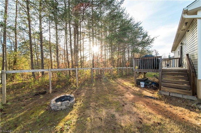 view of yard with a wooden deck and an outdoor fire pit