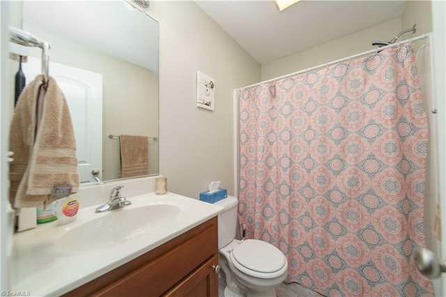 bathroom with curtained shower, vanity, and toilet