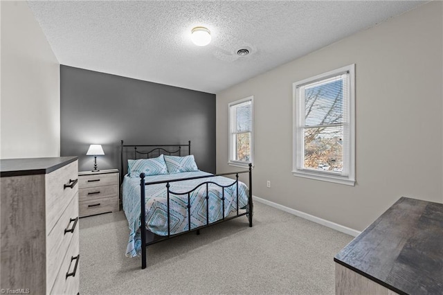 bedroom featuring light carpet and a textured ceiling