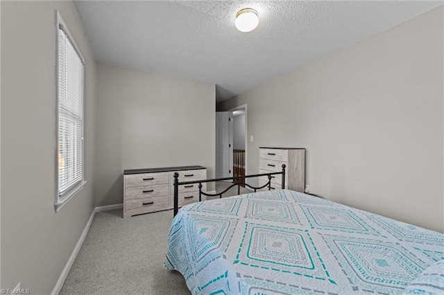 bedroom featuring a textured ceiling and light colored carpet