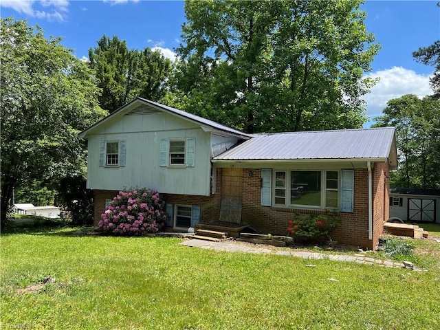 118 Laurel Dr, Mount Airy, NC 27030 - tri-level home with a front yard, brick siding, a storage unit, metal roof, and an outdoor structure