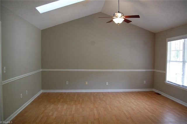 4711 Tuliptree Dr, Greensboro, NC 27455 - unfurnished room with a skylight, light wood finished floors, vaulted ceiling, ceiling fan, and baseboards