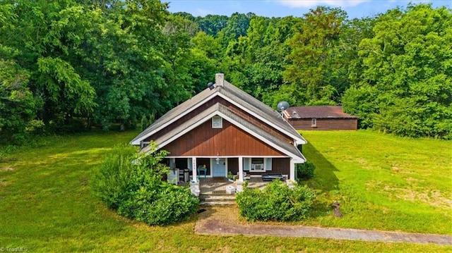 3608 Bernie Rd, Climax, NC 27233 - view of front facade with a porch, a front lawn, a view of trees, and a chimney