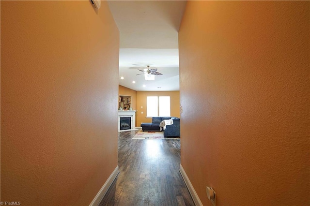 corridor with dark hardwood / wood-style flooring and lofted ceiling