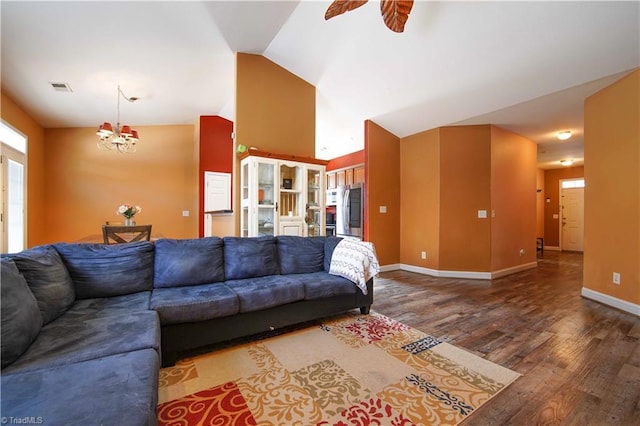 living room with hardwood / wood-style floors, ceiling fan with notable chandelier, and vaulted ceiling