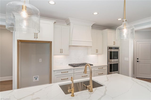 kitchen featuring custom exhaust hood, light stone countertops, stainless steel appliances, and decorative light fixtures