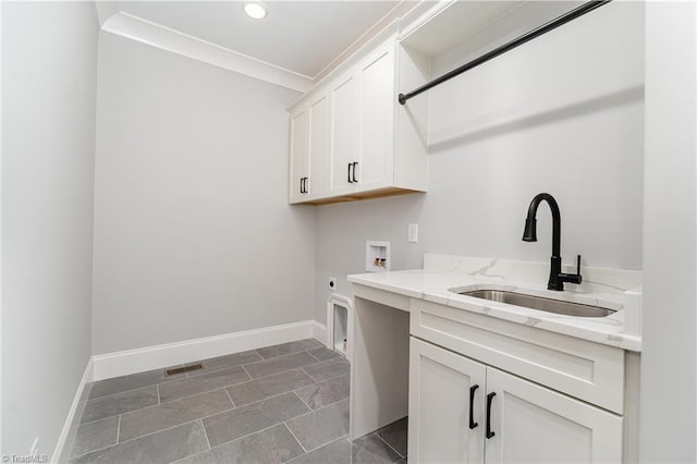 laundry room featuring electric dryer hookup, sink, hookup for a washing machine, and cabinets