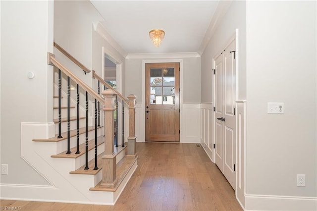 doorway to outside featuring light hardwood / wood-style flooring and ornamental molding