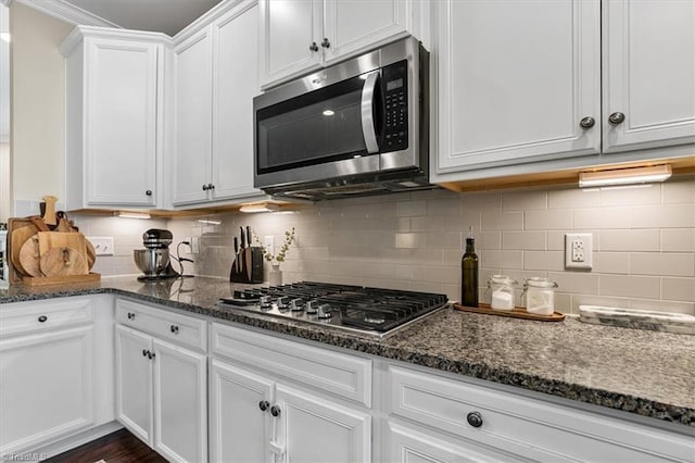 6605 Hedgerow Ct, Summerfield, NC 27358 - kitchen with stainless steel appliances, white cabinets, backsplash, and dark stone counters