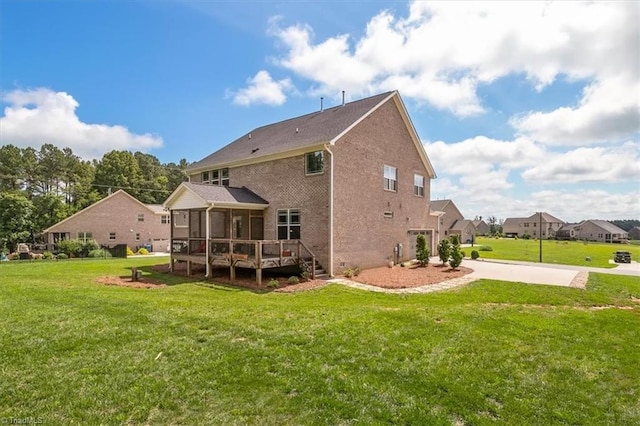 6605 Hedgerow Ct, Summerfield, NC 27358 - back of house featuring a sunroom, brick siding, a yard, and a deck