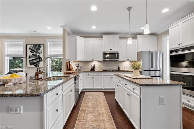 6605 Hedgerow Ct, Summerfield, NC 27358 - kitchen featuring appliances with stainless steel finishes, a sink, ornamental molding, a peninsula, and recessed lighting