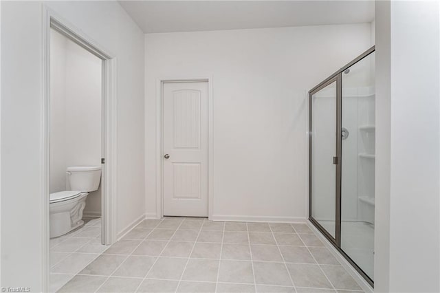 bathroom with tile patterned flooring, an enclosed shower, and toilet