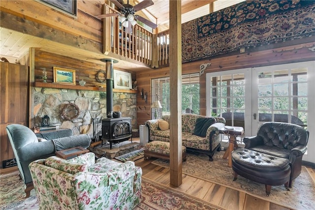 1215 Single Tree Rd, Westfield, NC 27016 - living area featuring hardwood / wood-style flooring, a wood stove, ceiling fan, wood walls, and a high ceiling