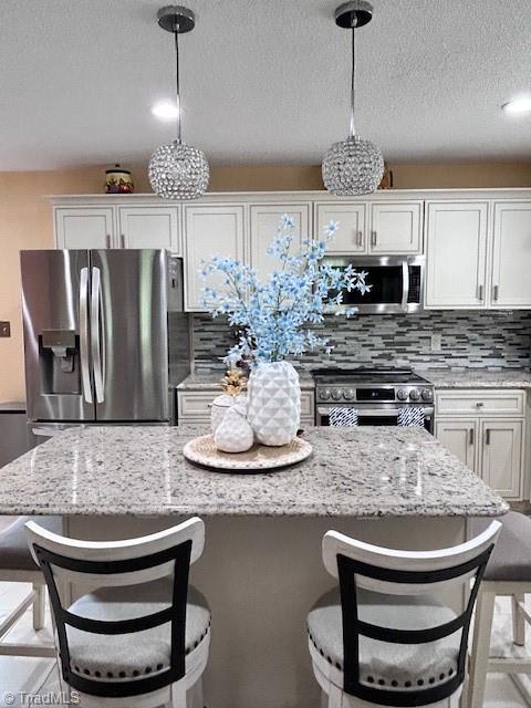 1320 Little Gate Dr, Asheboro, NC 27205 - kitchen featuring stainless steel appliances, white cabinetry, backsplash, light stone counters, and a textured ceiling