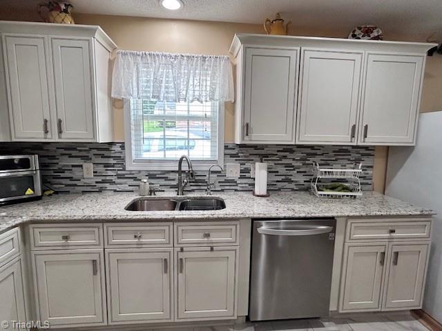 1320 Little Gate Dr, Asheboro, NC 27205 - kitchen with stainless steel dishwasher, backsplash, and white cabinetry