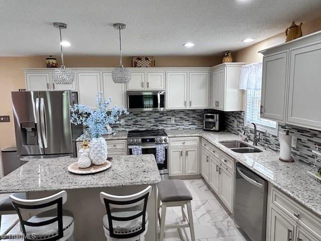 1320 Little Gate Dr, Asheboro, NC 27205 - kitchen featuring stainless steel appliances, light marble finish flooring, a kitchen island, a kitchen bar, and white cabinets