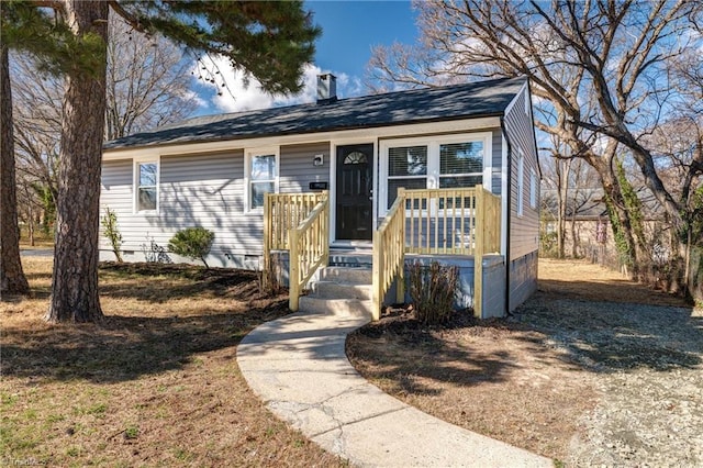 view of front of home with a porch, crawl space, and a chimney