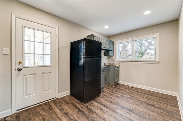 kitchen featuring dark wood-type flooring, freestanding refrigerator, gray cabinetry, and baseboards