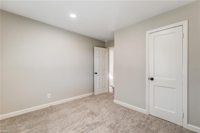 unfurnished bedroom featuring carpet, baseboards, and recessed lighting