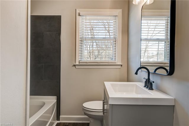 bathroom featuring toilet, vanity, baseboards, walk in shower, and a bathtub