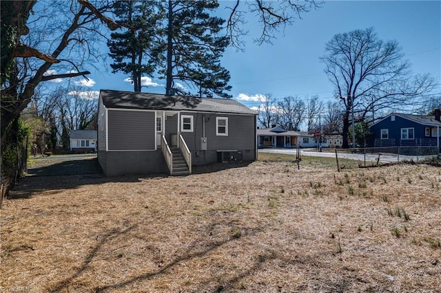 rear view of property with central AC unit and fence