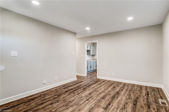 interior space featuring dark wood-style floors, baseboards, visible vents, and recessed lighting