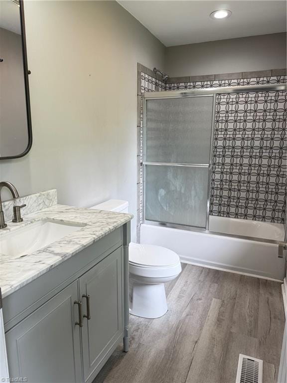 169 Pine View Rd, Eden, NC 27288 - full bathroom featuring visible vents, bath / shower combo with glass door, toilet, vanity, and wood finished floors
