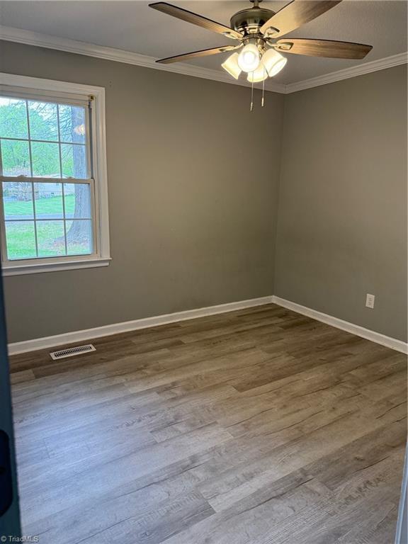 169 Pine View Rd, Eden, NC 27288 - unfurnished room with ceiling fan, ornamental molding, visible vents, wood finished floors, and baseboards