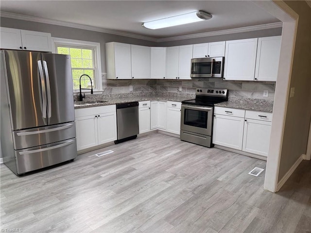 169 Pine View Rd, Eden, NC 27288 - kitchen with crown molding, light stone countertops, appliances with stainless steel finishes, a sink, and light wood finished floors