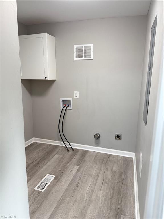 169 Pine View Rd, Eden, NC 27288 - laundry area featuring visible vents, baseboards, wood finished floors, and cabinet space