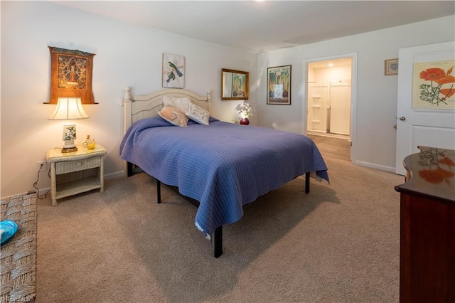 carpeted bedroom featuring baseboards and ensuite bathroom