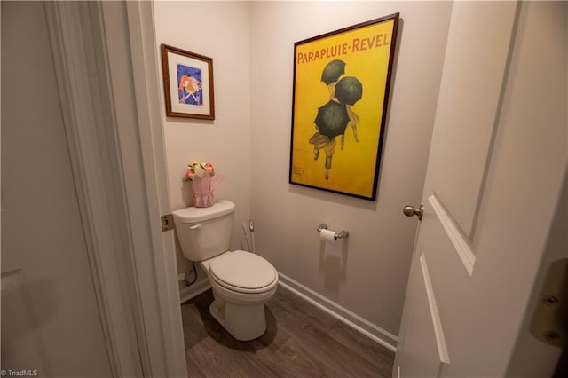 bathroom with wood finished floors, toilet, and baseboards