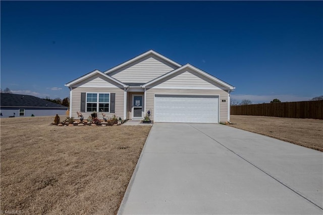 view of front of house featuring an attached garage, concrete driveway, a front yard, and fence