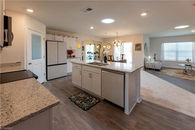 kitchen with stainless steel microwave, white cabinets, dishwasher, and freestanding refrigerator