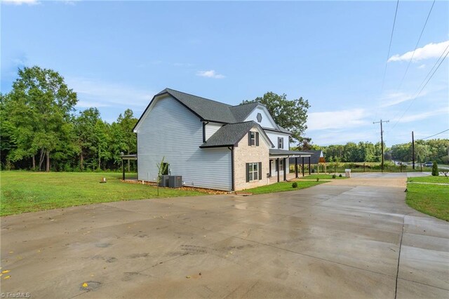 view of property exterior featuring central air condition unit and a lawn