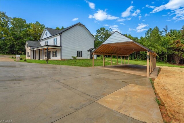 view of home's exterior featuring a carport, a yard, and a porch