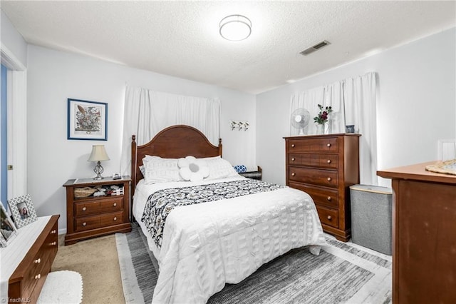 bedroom featuring a textured ceiling and visible vents