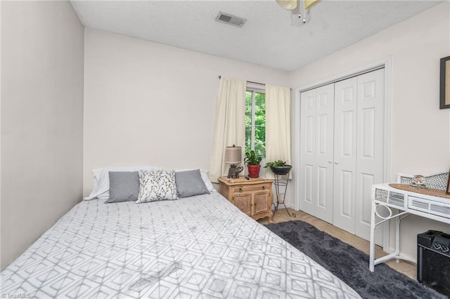 carpeted bedroom featuring ceiling fan, visible vents, and a closet