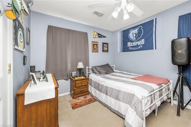 carpeted bedroom with baseboards, ceiling fan, a textured ceiling, and visible vents