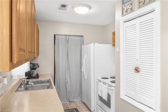 kitchen featuring a textured ceiling, visible vents, white range with electric cooktop, a sink, and light countertops