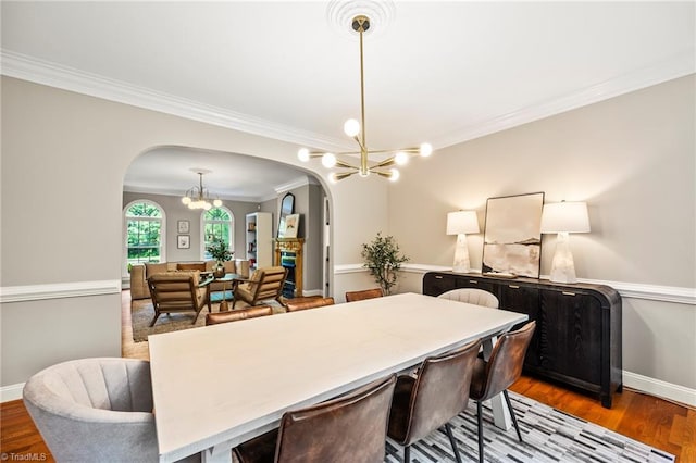 dining space featuring hardwood / wood-style flooring, crown molding, and a notable chandelier