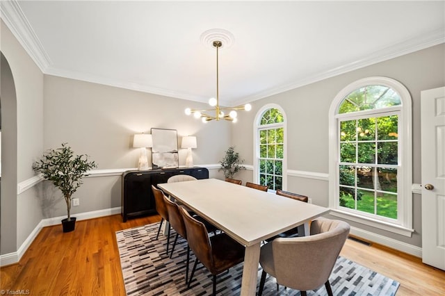 dining space featuring an inviting chandelier, crown molding, and light hardwood / wood-style floors