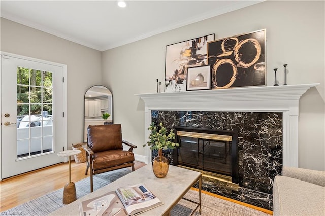 sitting room featuring wood-type flooring, crown molding, and a fireplace